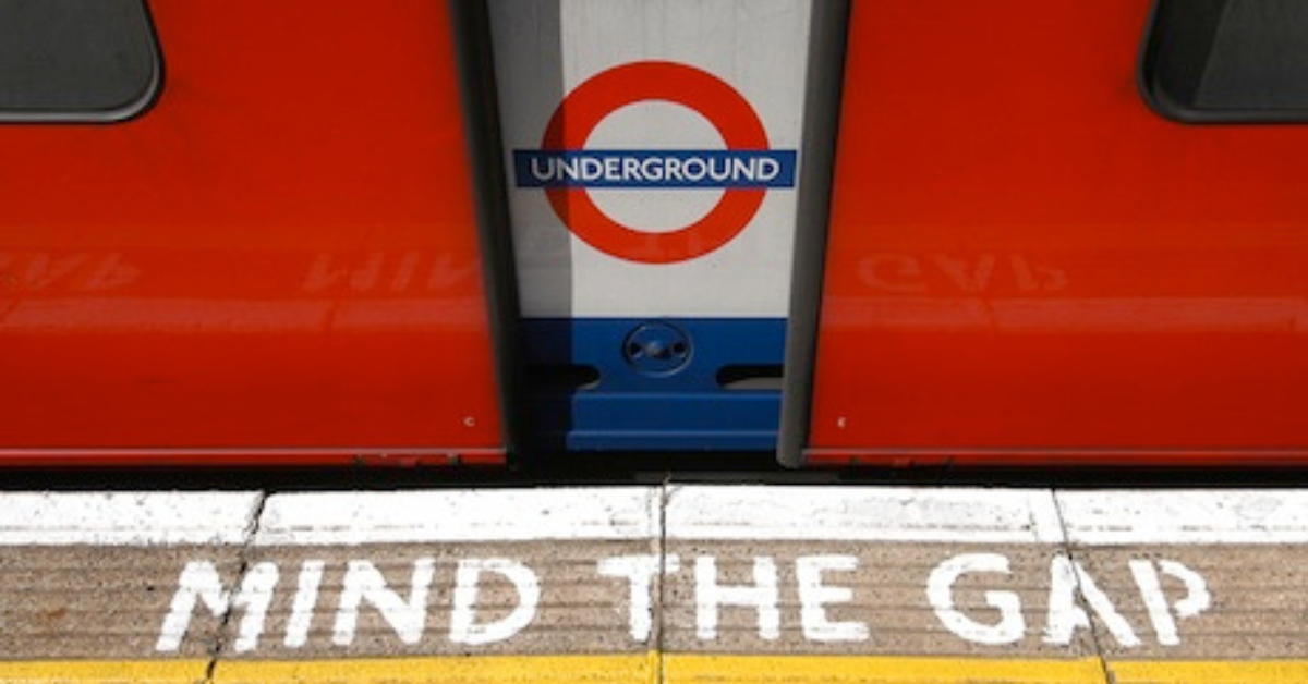 Close up of London Underground train door with logo and Mind the Gap signage on the ground